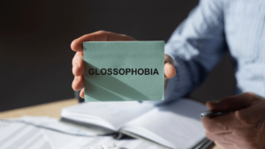 hand holding a card that reads Glossophobia
